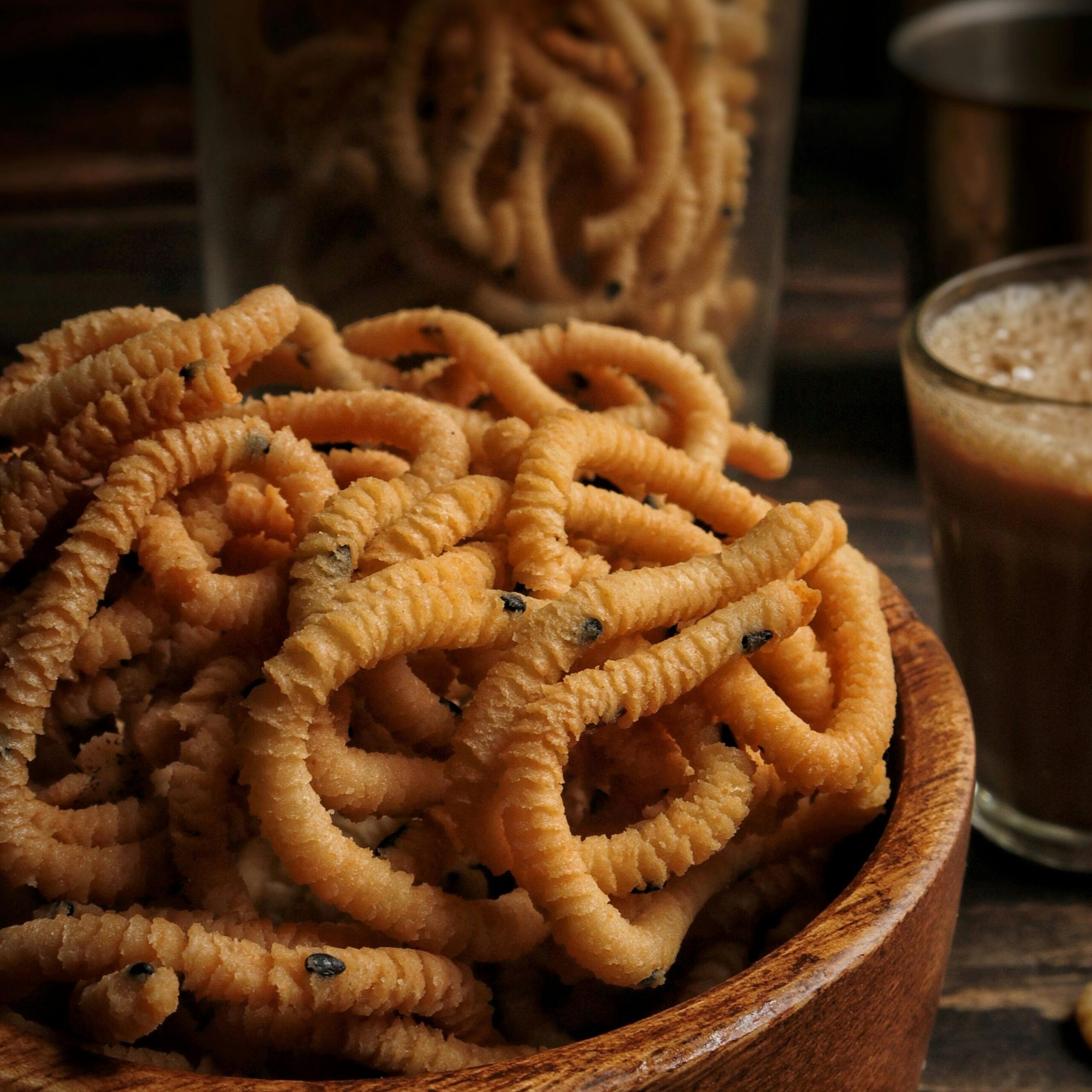 Crispy murukku served in a wooden bowl, perfect for a tasty snack experience.